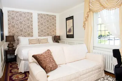 a bedroom with a white bed and a couch at The Craigmyle Inn in Victoria