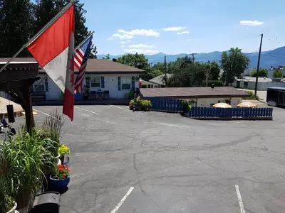 a parking lot with two flags in front of a house at Creston Valley Motel in Creston