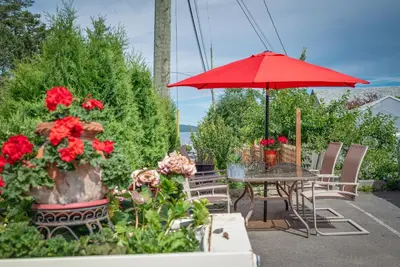 a table with a red umbrella and some flowers at Croft Inn Motel in Crofton
