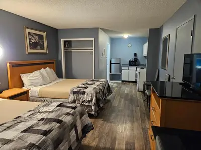 a hotel room with two beds and a flat screen tv at Metro Inn in Victoria