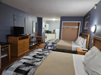 a hotel room with two beds and a television at Metro Inn in Victoria