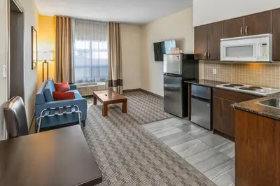 a hotel room with a kitchen and a living room at Comfort Inn in Dawson Creek