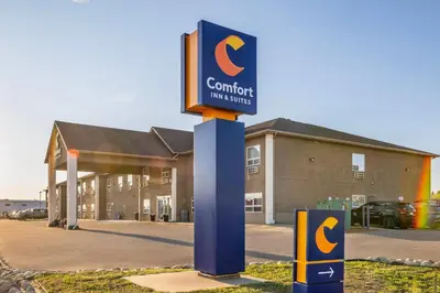 a sign in front of a building with a building at Comfort Inn in Dawson Creek