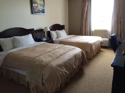 a hotel room with two beds and a window at Days Inn by Wyndham Athabasca in Athabasca