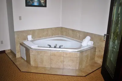 a bath tub in a room with a tile wall at Days Inn by Wyndham Athabasca in Athabasca