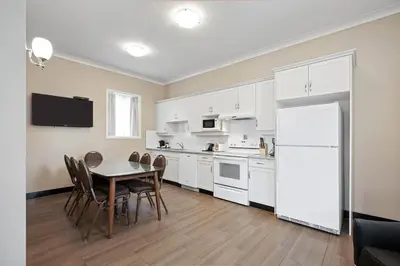 a kitchen with a table and a white refrigerator at Glenwood Inn & Suites in Trail