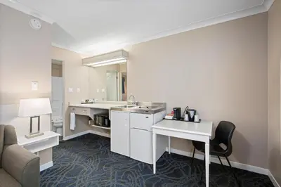 a hotel room with a sink and a living room at Glenwood Inn & Suites in Trail