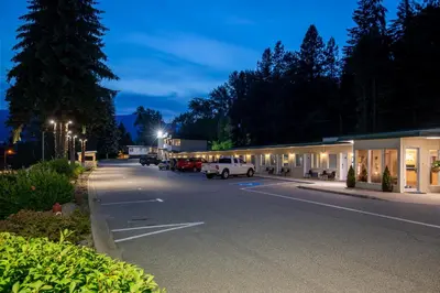 a parking lot in front of a building at night at Glenwood Inn & Suites in Trail