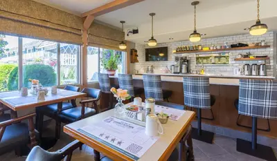 a restaurant with tables and chairs and a bar at Grama's Inn in Prince George