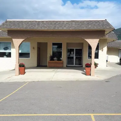 a building with a parking lot in front of it at Magnuson Hotel Creston in Creston