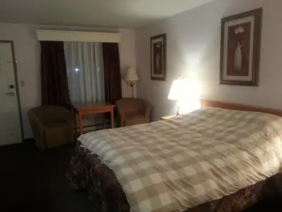 a hotel room with a bed and a desk at Heritage Inn in Hope