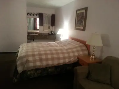 a hotel room with a bed and a chair at Heritage Inn in Hope