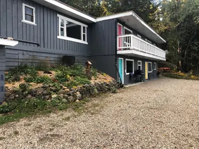 a black house with a porch and a balcony at Jasper Way Inn Resort & Campground in Clearwater