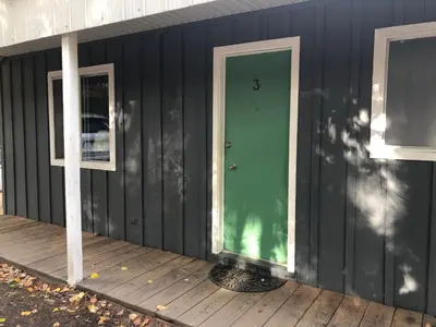 a green door on the side of a house at Jasper Way Inn Resort & Campground in Clearwater