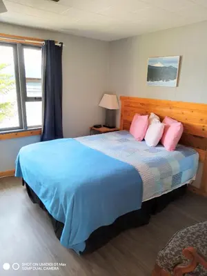 a bedroom with a large bed with pink pillows at Jasper Way Inn Resort & Campground in Clearwater