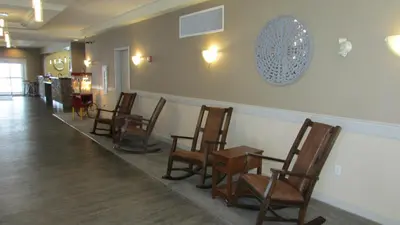 a waiting room with chairs and a wall with a clock at Days Inn & Suites by Wyndham Brooks in Brooks