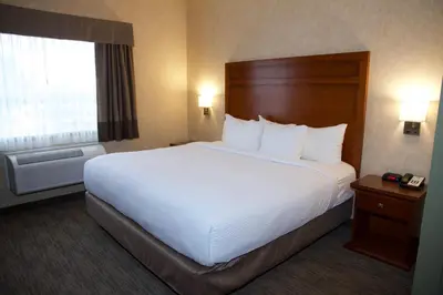 a hotel room with a large bed and a window at Days Inn & Suites by Wyndham Brooks in Brooks