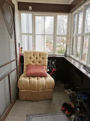 a chair with a red pillow in a room with windows at John's House in Vancouver West in Vancouver