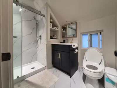 a bathroom with a toilet and a shower and a sink at John's House in Vancouver West in Vancouver