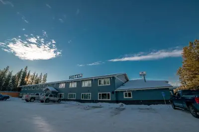 a hotel in a parking lot in the snow at Northway Motor Inn in Dease Lake