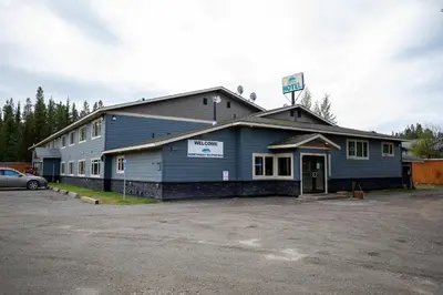 a building with a parking lot in front of it at Northway Motor Inn in Dease Lake
