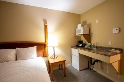 a hotel room with a bed and a desk at Northway Motor Inn in Dease Lake