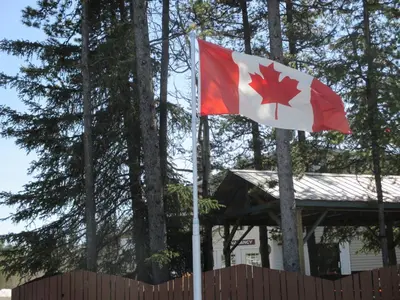 a canadian flag flying in front of a house at Northway Motor Inn in Dease Lake