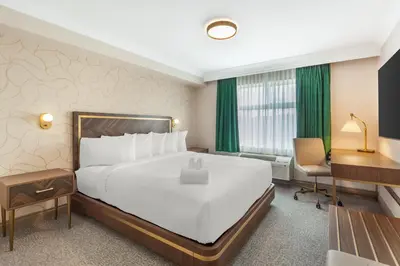 a hotel room with a large bed and a desk at Velora Hinton, an Ascend Collection Hotel in Hinton