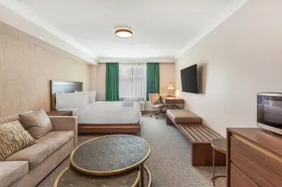 a hotel room with a bed and a couch at Velora Hinton, an Ascend Collection Hotel in Hinton