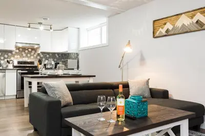 a living room with a couch and a table with wine glasses at Modern Executive Suite I Complimentary Netflix & Parking! in Edmonton