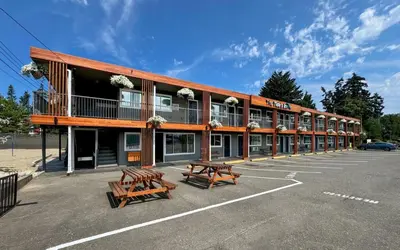 a building with two benches in a parking lot at The Tide's Inn in Parksville