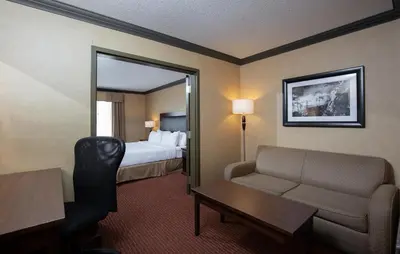 a hotel room with a bed and a couch and a table at Pomeroy Hotel Fort St. John in Fort Saint John