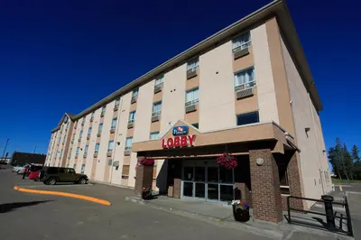 a hotel building with a jocky sign on it at Pomeroy Inn & Suites Fort St. John in Fort Saint John