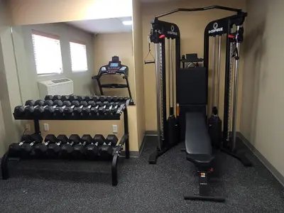 a gym with lots of equipment in a room at Central Suite Hotel in Lloydminster
