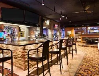 a bar with a row of chairs in a restaurant at Central Suite Hotel in Lloydminster