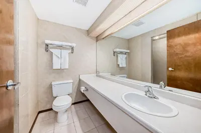 a bathroom with a toilet and a sink at Stony Plain Inn & Suites in Stony Plain