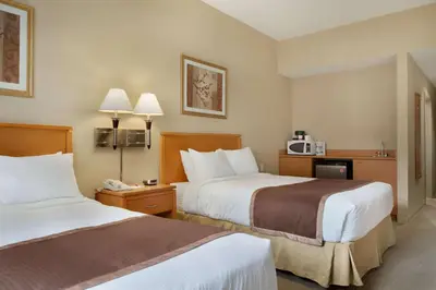a hotel room with two beds and a microwave at Ramada by Wyndham Nanaimo in Nanaimo