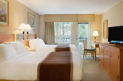 a hotel room with two beds and a television at Ramada by Wyndham Nanaimo in Nanaimo