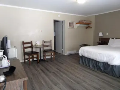a hotel room with a bed and a table and chairs at Ray Lyn Motel in Trail