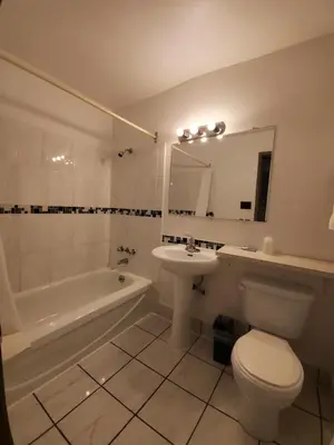 a bathroom with a toilet and a sink and a tub at Red Roof Motor Inn in Hope