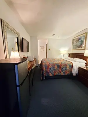 a hotel room with a bed and a television at Red Roof Motor Inn in Hope