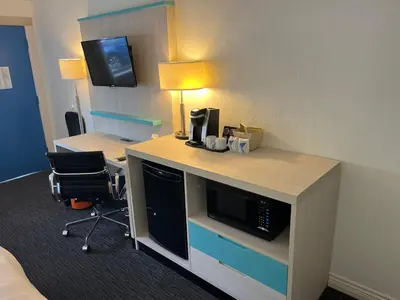 a hotel room with a desk with a computer and a chair at Revelstoke Lodge in Revelstoke