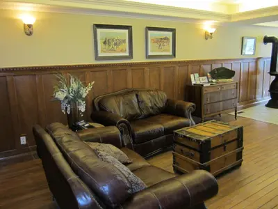 a living room with a leather couch and a chair at Reynolds Hotel in Lillooet