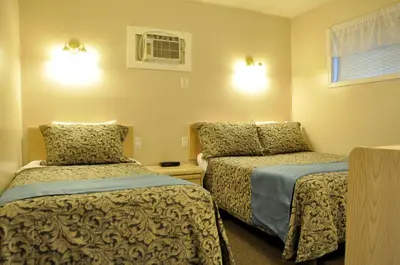 a bedroom with two beds and a window at Rosedale Motel in Summerland