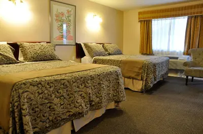 a hotel room with two beds and a window at Rosedale Motel in Summerland