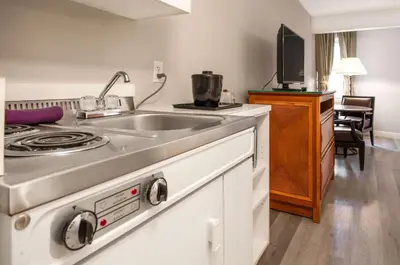 a kitchen with a stove and a sink at Coast Parksville Hotel in Parksville