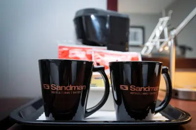two black coffee mugs sitting on a tray at Sandman Inn Cache Creek in Cache Creek