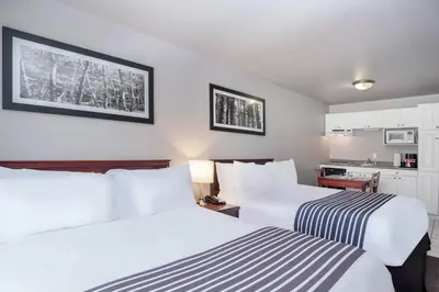 a hotel room with two beds and a kitchen at Sandman Inn Cache Creek in Cache Creek