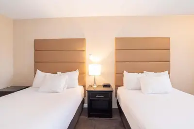 a hotel room with two beds and a lamp at Sandman Hotel Cranbrook in Cranbrook