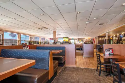 a restaurant with tables and chairs and a bar at Sandman Hotel Cranbrook in Cranbrook